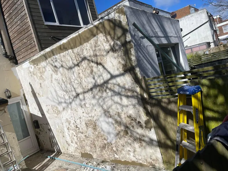 Flaking and damaged exterior render before repair