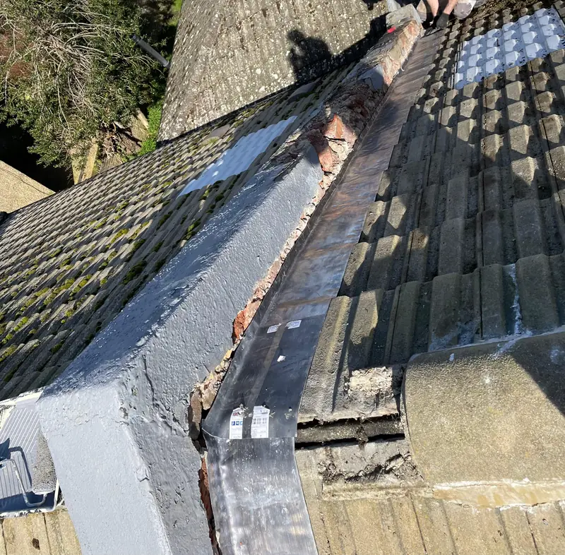 Damaged roof valley with cracked lead flashing